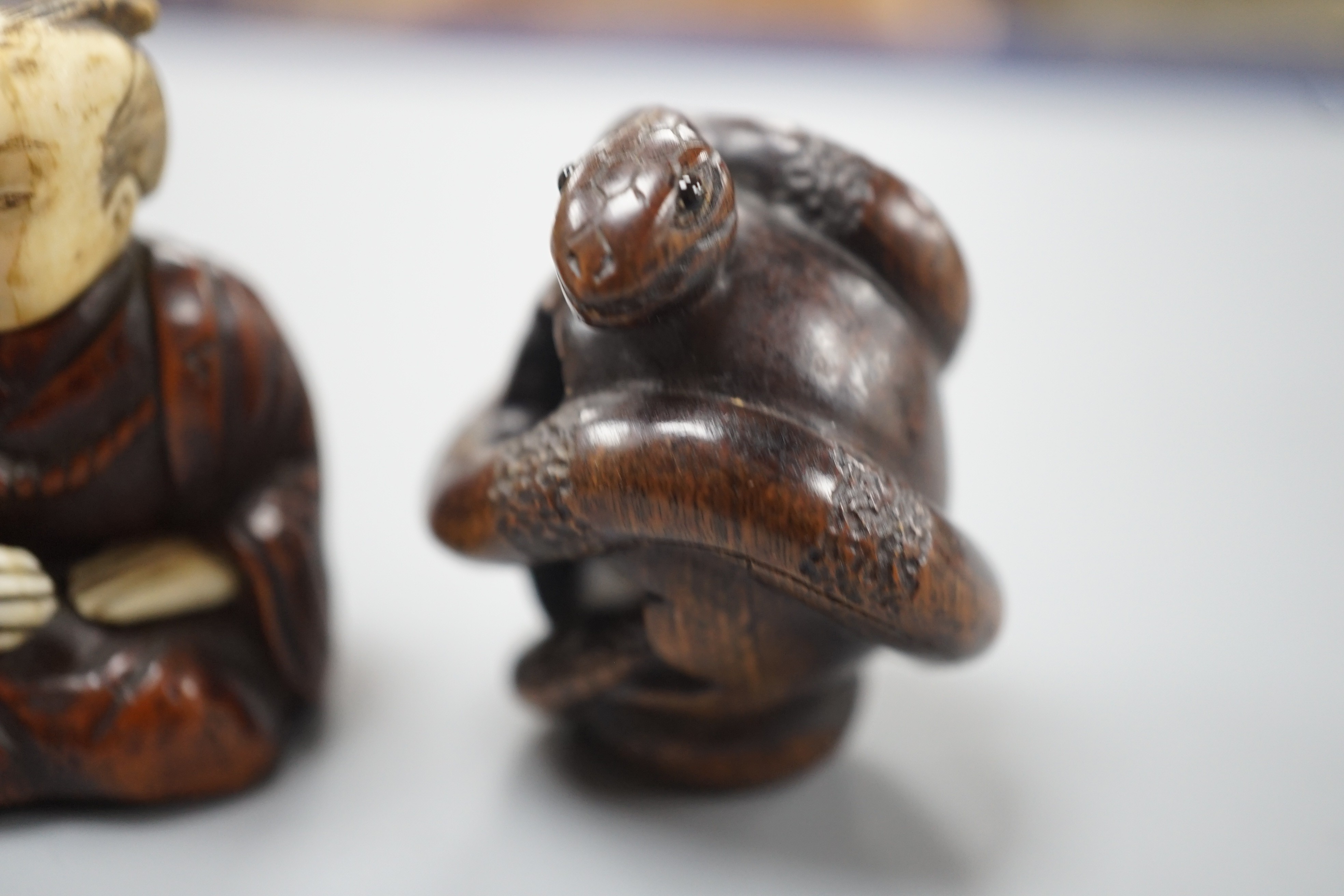 A Continental wood ‘chick and egg’ brooch ivory, 5.3cm, a Japanese ivory and wood figure and a wood netsuke of snakes (3)